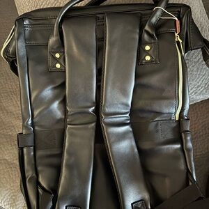 Sleek Black Backpack with Padded Straps and Gold Hardware